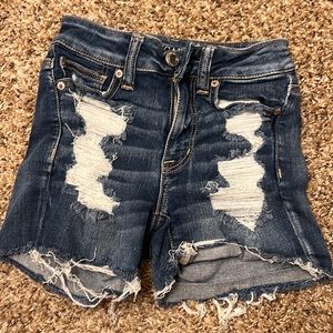 Dark blue American Engle shorts with rips and patches.